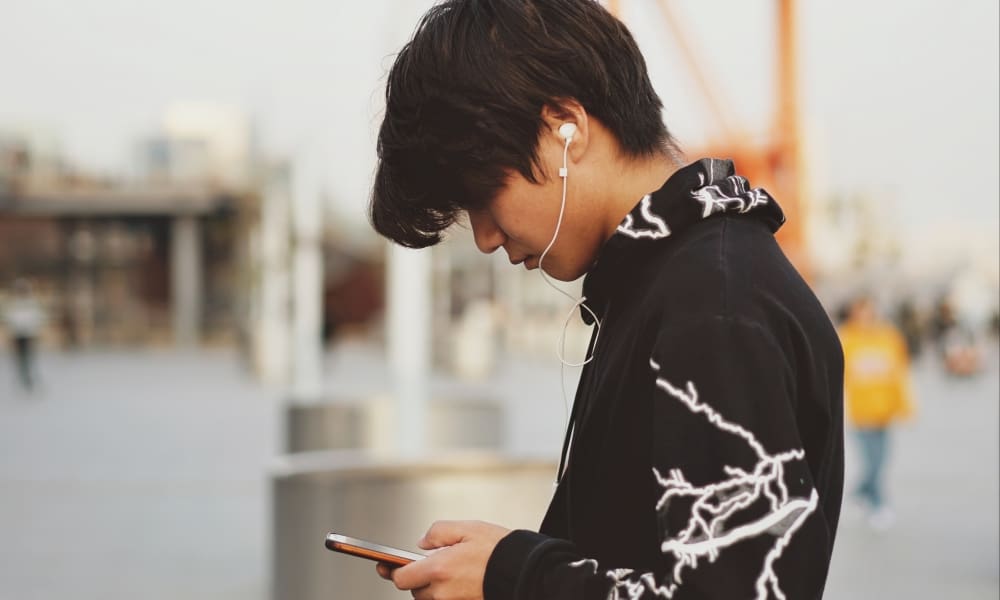 Joven escuchando música en su celular,